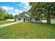 Charming home with a well-manicured lawn, a concrete driveway, and a mature tree at 6511 Se 25Th Ave, Ocala, FL 34480