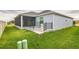 This backyard has a screened porch and an elevated patio with black railings at 6877 Minchew Cir, The Villages, FL 34762