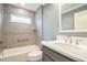 Bathroom featuring tiled walls, a single sink vanity, and a shower and tub combo at 6877 Minchew Cir, The Villages, FL 34762