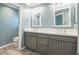 Bathroom featuring dual sinks, gray cabinets, and quartz countertops at 6877 Minchew Cir, The Villages, FL 34762