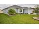 Single-story home with a well-maintained lawn, complemented by attractive landscaping and a flowering tree at 6877 Minchew Cir, The Villages, FL 34762