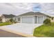 Attractive home with a spacious driveway, two-car garage, and manicured lawn at 6877 Minchew Cir, The Villages, FL 34762
