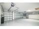 Spacious garage with epoxy flooring, overhead lighting, and built in storage cabinets at 6877 Minchew Cir, The Villages, FL 34762