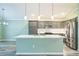 Bright and airy kitchen with gray cabinetry, a large center island, and stainless steel appliances at 6877 Minchew Cir, The Villages, FL 34762