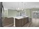 Kitchen featuring a center island with seating, stainless steel appliances, and a view of the living area at 6877 Minchew Cir, The Villages, FL 34762