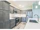 Well-equipped kitchen featuring gray cabinetry, stainless steel appliances, and quartz countertops at 6877 Minchew Cir, The Villages, FL 34762