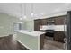 Modern kitchen with a center island, stainless steel appliances, and views to the living area and patio at 6877 Minchew Cir, The Villages, FL 34762
