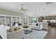 Open-concept living room with modern furnishings, a ceiling fan, and sliding glass doors to the patio at 6877 Minchew Cir, The Villages, FL 34762