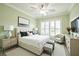 This main bedroom is well-lit, with a ceiling fan, lots of natural light, and coordinated decor at 6877 Minchew Cir, The Villages, FL 34762