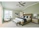 Bright main bedroom with vaulted ceilings, neutral carpet, and a seating area at 6877 Minchew Cir, The Villages, FL 34762