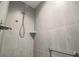 Modern shower with gray tiled walls, a rainfall showerhead, a shower niche, and a grab bar at 6877 Minchew Cir, The Villages, FL 34762