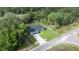 An aerial view captures this quaint home nestled among lush trees, showcasing its private lot at 75 Guava Ter, Ocklawaha, FL 32179