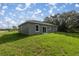 The backyard with its well-maintained lawn leads to a sliding glass door entry to the home at 75 Guava Ter, Ocklawaha, FL 32179