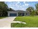 Charming single-story home features a well-maintained lawn and a driveway leading to an attached garage at 75 Guava Ter, Ocklawaha, FL 32179