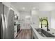 The contemporary kitchen boasts white cabinets, stainless steel appliances, and a spacious island at 75 Guava Ter, Ocklawaha, FL 32179