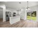 The kitchen features stainless appliances, white cabinets, a center island, and a sliding door to the backyard at 75 Guava Ter, Ocklawaha, FL 32179