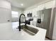 Bright kitchen featuring stainless steel appliances, quartz countertops, and a stylish island with a sink at 75 Guava Ter, Ocklawaha, FL 32179