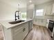 Bright kitchen with stainless appliances, quartz countertops and island seating with designer pendant lighting at 75 Guava Ter, Ocklawaha, FL 32179