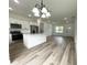 Open concept living room with hardwood floors connected to a modern, well-lit kitchen at 75 Guava Ter, Ocklawaha, FL 32179
