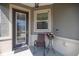 Cozy front porch featuring a decorative glass front door, chair, and small table with flower arrangement at 7881 Sw 89Th Cir, Ocala, FL 34481