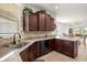 Well lit kitchen showcasing stone countertops, stainless steel sink, and dark wood cabinetry at 7881 Sw 89Th Cir, Ocala, FL 34481