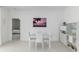 Minimalist dining area with white table, chairs, and adjacent storage unit at 8802 Sw 79Th Loop, Ocala, FL 34481