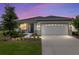 Charming single-story home with a well-manicured lawn and two-car garage, beautifully lit against a colorful evening sky at 8802 Sw 79Th Loop, Ocala, FL 34481