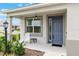 Charming front porch features a blue entry door, a comfortable seating area, and stylish outdoor lighting at 8802 Sw 79Th Loop, Ocala, FL 34481