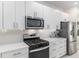 Close up of the kitchen with stainless steel appliances, white cabinets, and light countertops at 8802 Sw 79Th Loop, Ocala, FL 34481