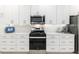 Kitchen showcases stainless steel oven, microwave and sleek white cabinets and light counter tops at 8802 Sw 79Th Loop, Ocala, FL 34481
