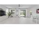 Open floor plan living room with white tile floors, bright lighting and access to an outdoor living space at 8802 Sw 79Th Loop, Ocala, FL 34481