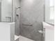 Modern shower with grey tiles, glass partition, a handrail, and white tiled floors at 8802 Sw 79Th Loop, Ocala, FL 34481
