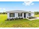 Charming single-story home featuring a well-manicured lawn, black shutters, and a welcoming entrance at 9 Redwood Run Trce, Ocala, FL 34481