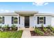 Inviting front entrance with a black door, fresh landscaping, and stylish shutters at 9 Redwood Run Trce, Ocala, FL 34481