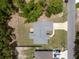 Aerial view of a house with a gray roof, concrete driveway, and lush green landscaping at 9432 Se 159Th Ln, Summerfield, FL 34491