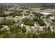 Aerial view of the neighborhood with lush green trees and the property marked with a yellow arrow at 9432 Se 159Th Ln, Summerfield, FL 34491