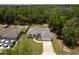 Aerial view of a home, highlighting the well-maintained landscaping, driveway, and proximity to lush greenery at 9432 Se 159Th Ln, Summerfield, FL 34491