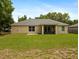 Back exterior view of the home featuring a screened patio and spacious backyard at 9432 Se 159Th Ln, Summerfield, FL 34491