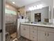 Modern bathroom with dual sinks, granite countertops, and a tiled walk-in shower at 9432 Se 159Th Ln, Summerfield, FL 34491