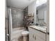 Well-lit bathroom featuring gray tiled walls, a shower with a curtain, and a granite countertop vanity at 9432 Se 159Th Ln, Summerfield, FL 34491