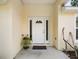 Close-up of the front door with side windows, a transom and surrounding landscaping at 9432 Se 159Th Ln, Summerfield, FL 34491