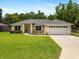 Charming single-story home with a well-manicured lawn, a two car garage and mature landscaping at 9432 Se 159Th Ln, Summerfield, FL 34491
