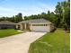 Charming single-story home with a well-manicured lawn, a two car garage and mature landscaping at 9432 Se 159Th Ln, Summerfield, FL 34491