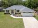 Charming single-story home with a well-manicured lawn, a two car garage and mature landscaping at 9432 Se 159Th Ln, Summerfield, FL 34491