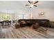 Spacious living room with light wood flooring, ceiling fan, large windows and plenty of natural light at 9432 Se 159Th Ln, Summerfield, FL 34491