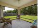 Enclosed patio featuring wicker furniture, screened windows, and a view of the fenced backyard at 9432 Se 159Th Ln, Summerfield, FL 34491