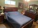 Cozy bedroom with dark wood furniture and a comfortable blue comforter at 1013 Nw Mandrake Dr, Dunnellon, FL 34431
