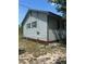 View of the side of a single Gathering home with vinyl siding and green trim at 1013 Nw Mandrake Dr, Dunnellon, FL 34431