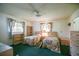 This bedroom includes two twin beds, a ceiling fan, and plenty of natural light at 10699 Se 178Th St, Summerfield, FL 34491