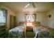 This bedroom features two twin beds, a ceiling fan, and two large windows at 10699 Se 178Th St, Summerfield, FL 34491